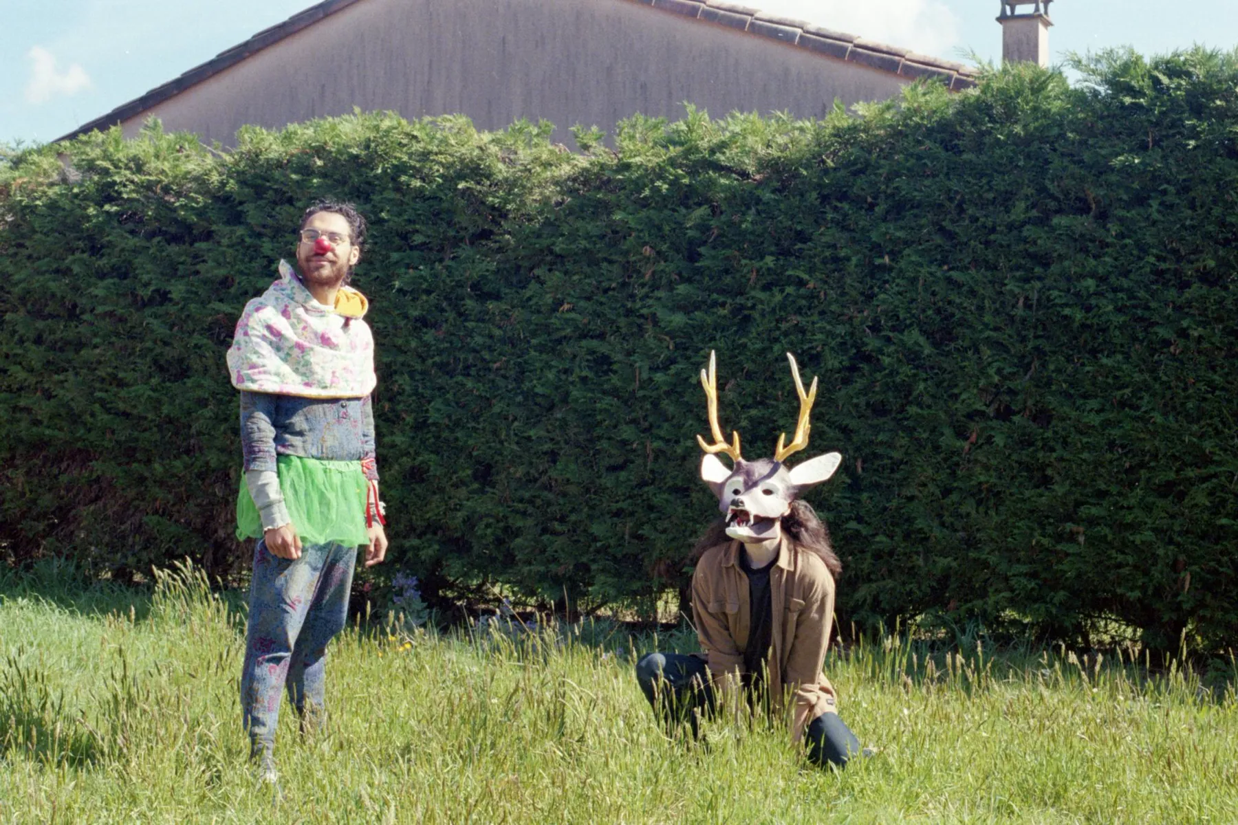 Deux comédiens en lisière de forêt, l'un avec un masque de cervidé